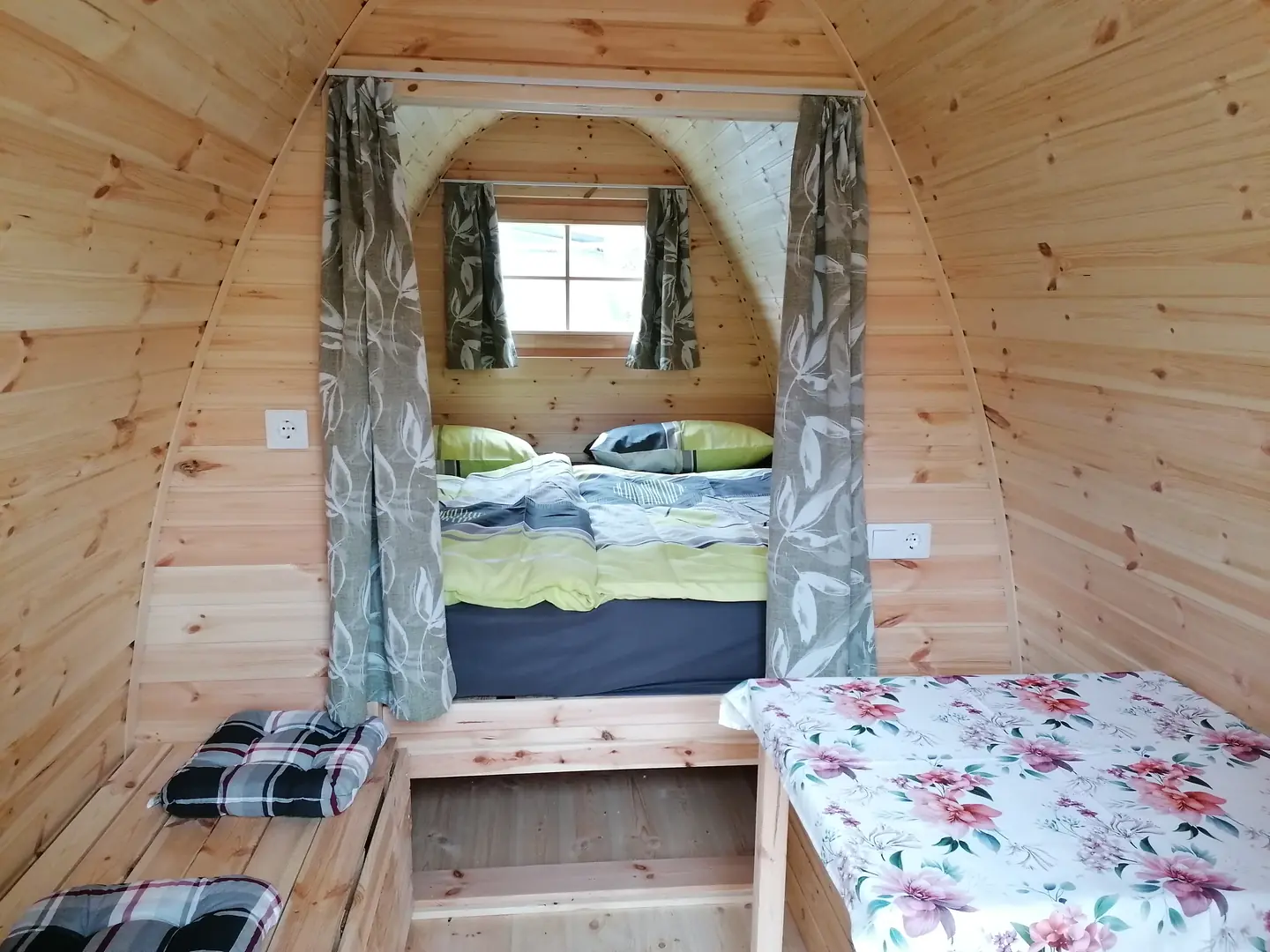 Innenansicht des Camping Pods mit Schlafbereich und Sitzecke